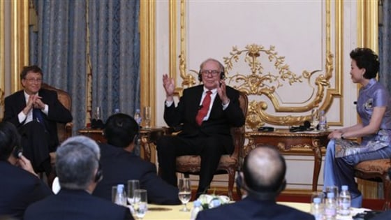 Bill Gates, left, and Warren Buffett, center, talk with some of China's richest people to promote philanthropy during a dinner and reception Wednesday in Beijing.